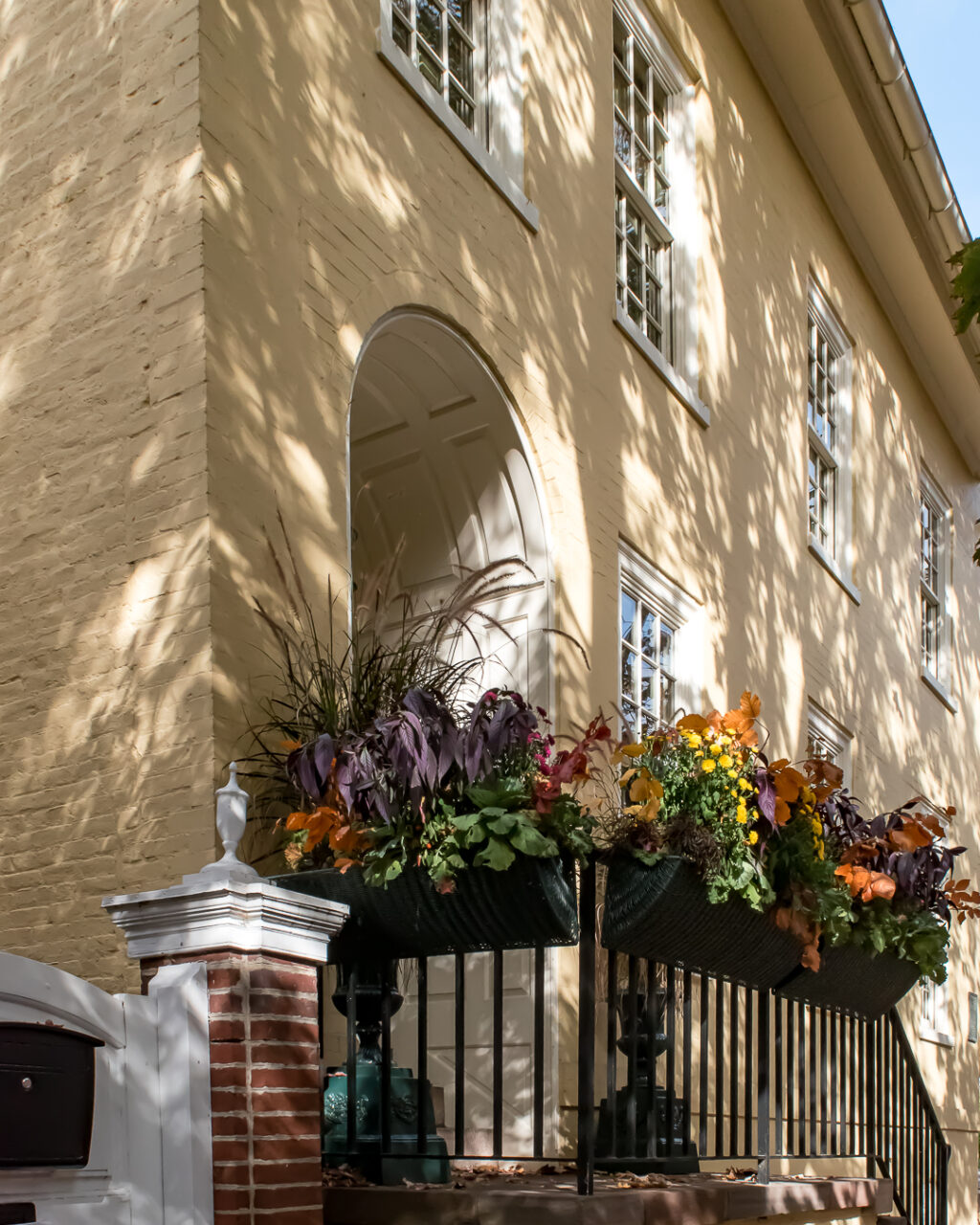 Yellow house with fall porch decorations